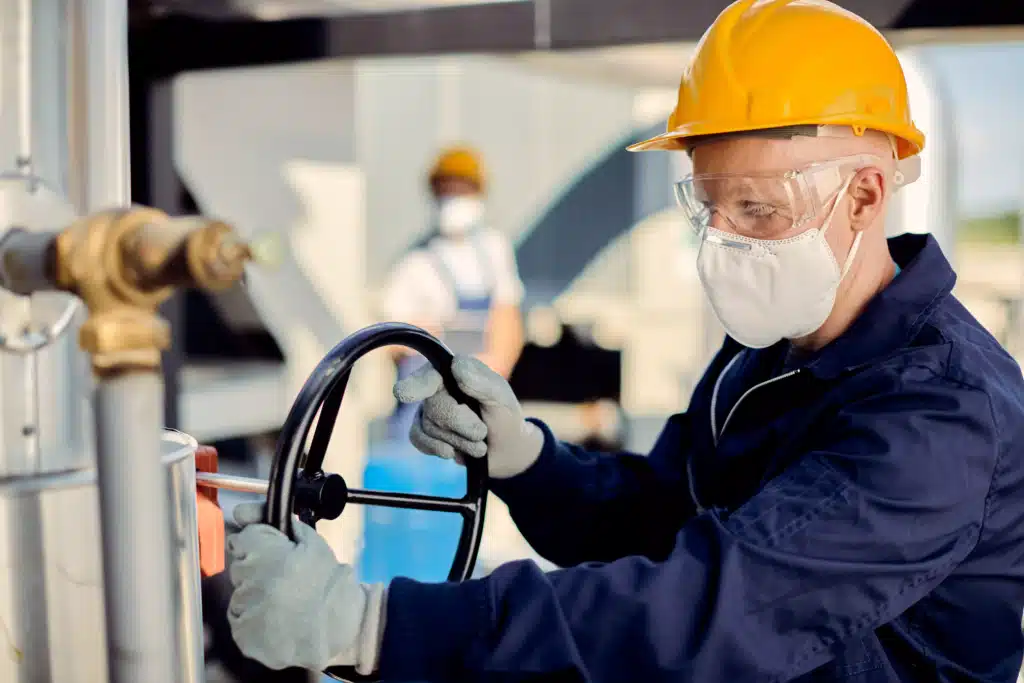 albino-worker-with-face-mask-tightening-valve-construction-site